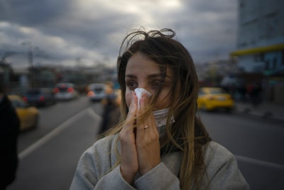 woman outside sneezingh