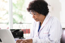 Female doctor working on a laptop computer.