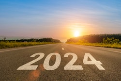 2024 written across a highway heading into the sunrise