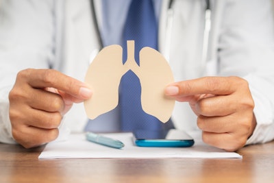 Picture of doctor holding paper cutout of lungs