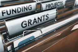 The photo displays a file drawer with file folders labeled 'funding,' 'grants' and 'projects.'