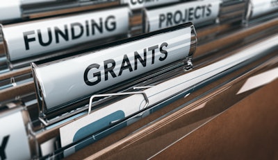 The photo displays a file drawer with file folders labeled 'funding,' 'grants' and 'projects.'