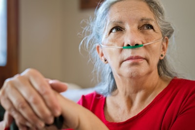 Older woman with oxygen tube in her nose.