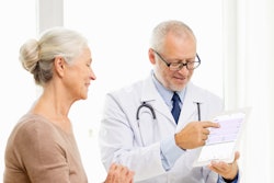 Photo of a male doctor showing a female patient data on a tablet.