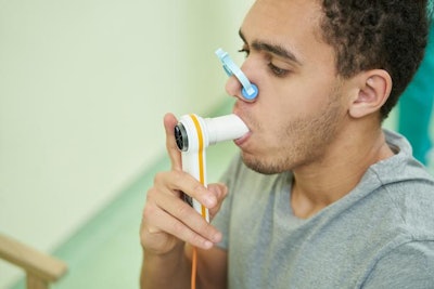 Black male being tested with a spirometer.
