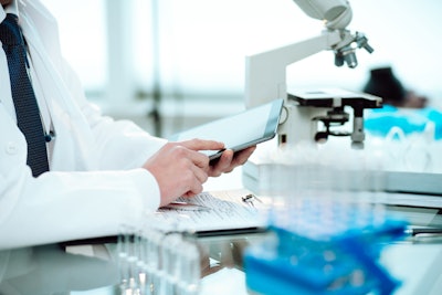 Scientist using a digital tablet in a science lab.