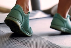 Photo of feet in running shoes on a treadmill.