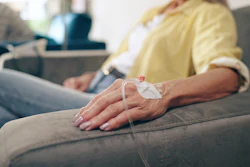 Healthcare, hands and senior woman with iv drip in a hospital for cancer, treatment or chemotherapy.