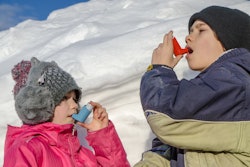 Young boy and girl using asthma pump after snow shoveling
