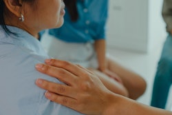 Woman with a comforting hand on her shoulder.