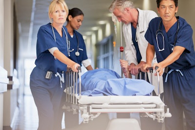 This is a photo of a patient being rushed into a hospital by medical staff.