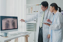 Image of a male and female doctor consulting over an x-ray of lungs.