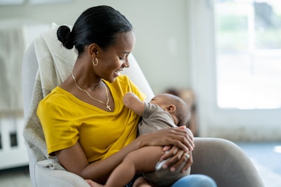 This is a photo of a young, Black woman breastfeeding her baby.