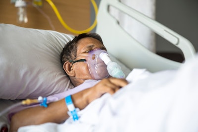 patient lying on Hospital bed with ventilator mask
