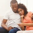 This is a photo of a sad Black family looking at a pregnancy test and learning they are not pregnant.