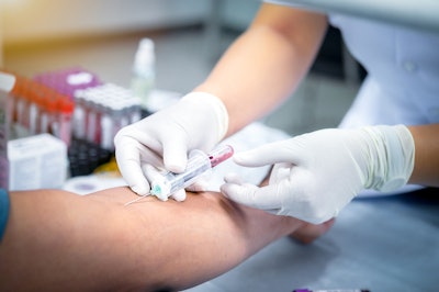 Image of blood being drawn in a syringe by a medical professional