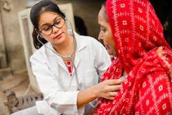Indian doctor uses a stethoscope on an Indian woman.