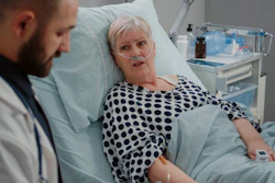Image of a doctor and a woman in a hospital bed with oxygen tubes in her nose.