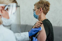 Photo of a doctor giving an older woman a shot.