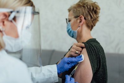 Photo of a doctor giving an older woman a shot.