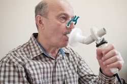 Senior Hispanic man testing breathing function