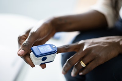African American person using pulse oximeter