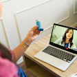 This is a photo of a female doctor and patient in a telehealth visit and one is holding an asthma inhaler.