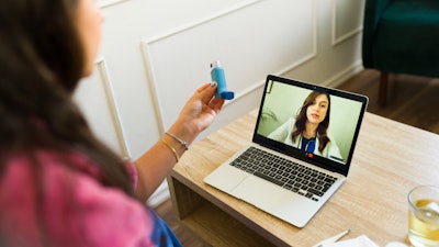 This is a photo of a female doctor and patient in a telehealth visit and one is holding an asthma inhaler.