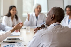This is a photo of a group of doctors in white coats discussing a case or protocol.