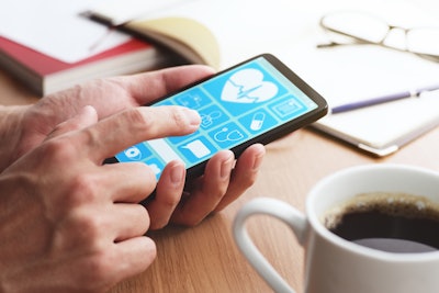 Image of hands using a mobile phone to check medical data.
