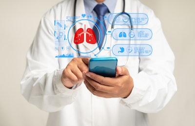 Image of a doctor looking at virtual images of lungs and medical data on a phone.