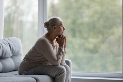 Image of an older woman looking out of the window.