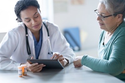 This is a photo of a female doctor telling a female patient how to take her meds.