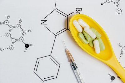 Assortment of Pills, Tablets and Capsules in Yellow Spoon, Syringe on White Background with Chemical Formula.