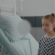 Young patient has lungs checked by doctor in hospital room