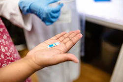 Shalini Prasad, PhD, holds a screen-printed electrochemical sensor.