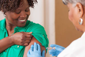 Healthcare worker in green scrubs administering vaccine injection to patient's arm