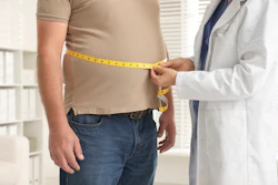 Doctor measuring patient's waist with yellow tape measure during health checkup