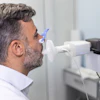 Man performing spirometry test with blue mouthpiece during pulmonary function assessment in medical clinic